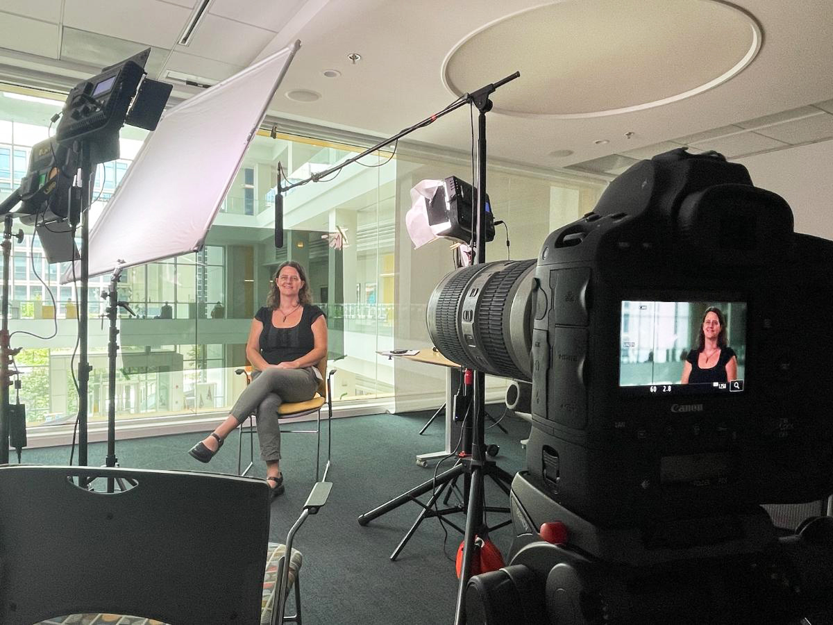 Shira sitting for an interview. Cameras and gear are in view